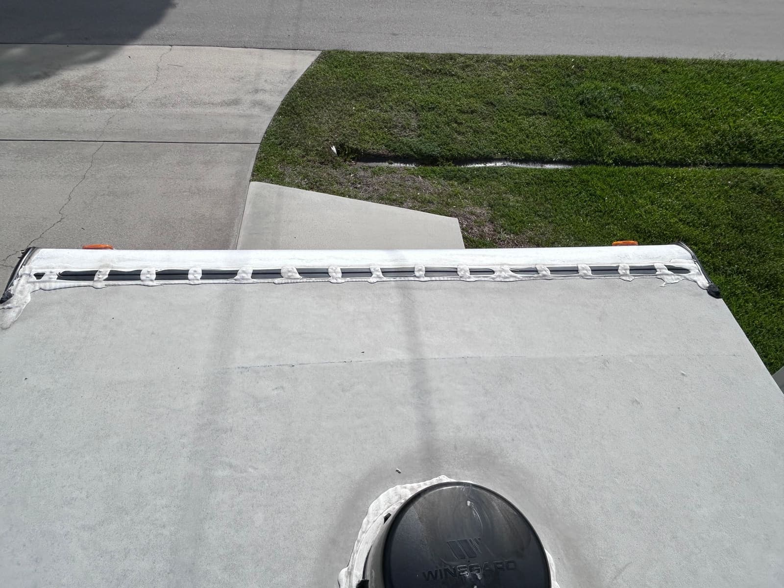 RV roof seam resealing with white lap sealant